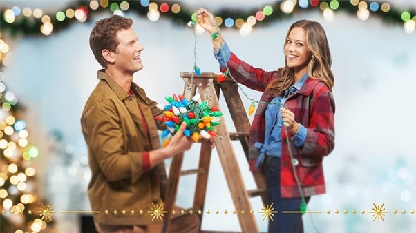 A couple hanging Christmas lights. Typical characters involved in writing Christmas films